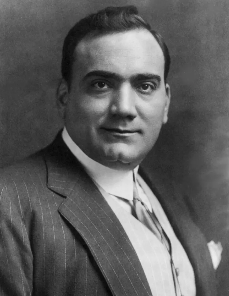 Sort-hvidt studioportræt af tenoren Enrico Caruso i jakkesæt med striber