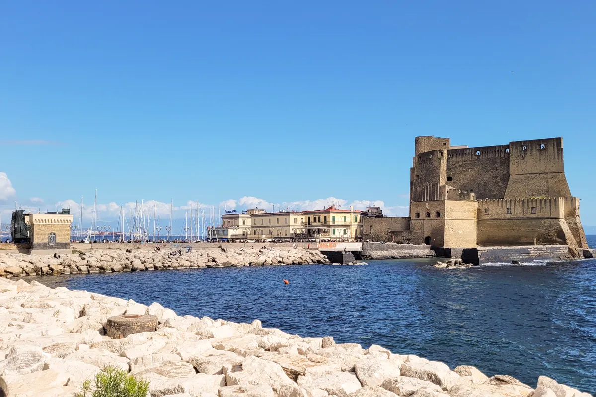 Castel dell'Ovo på sin klippeø i Napolibugten, set på tværs af en bølgebryder
