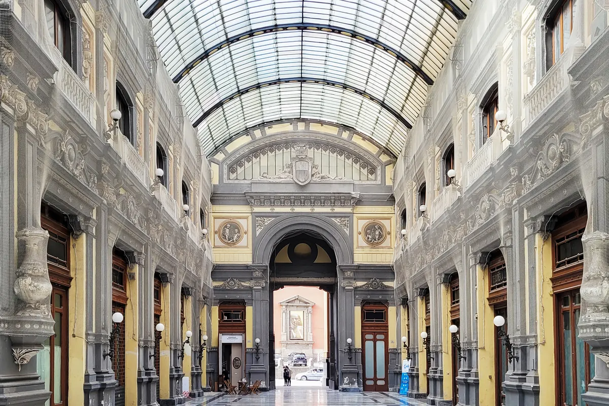 Skleněná a železná střecha a malované fasády uvnitř Galleria Principe di Napoli